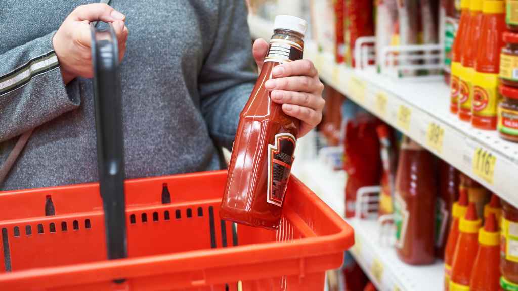 Un señor compra kétchup en el supermercado.