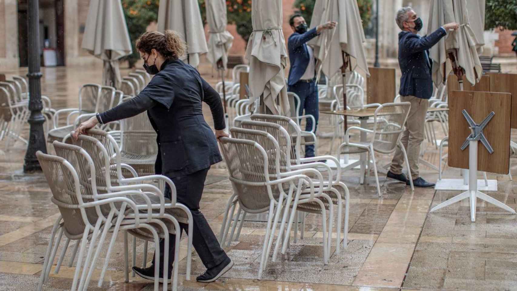 Camareros recogen una terraza en una plaza de Castilla y León. Efe