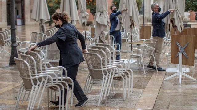 Camareros recogen una terraza en una plaza de Castilla y León. Efe