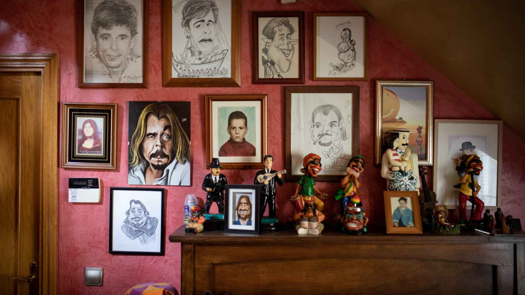 Fotos y caricaturas de Juan Muñoz en su pared.