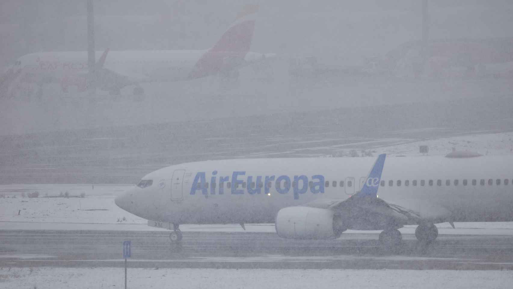 Un avión en Barajas en un día de nieve.