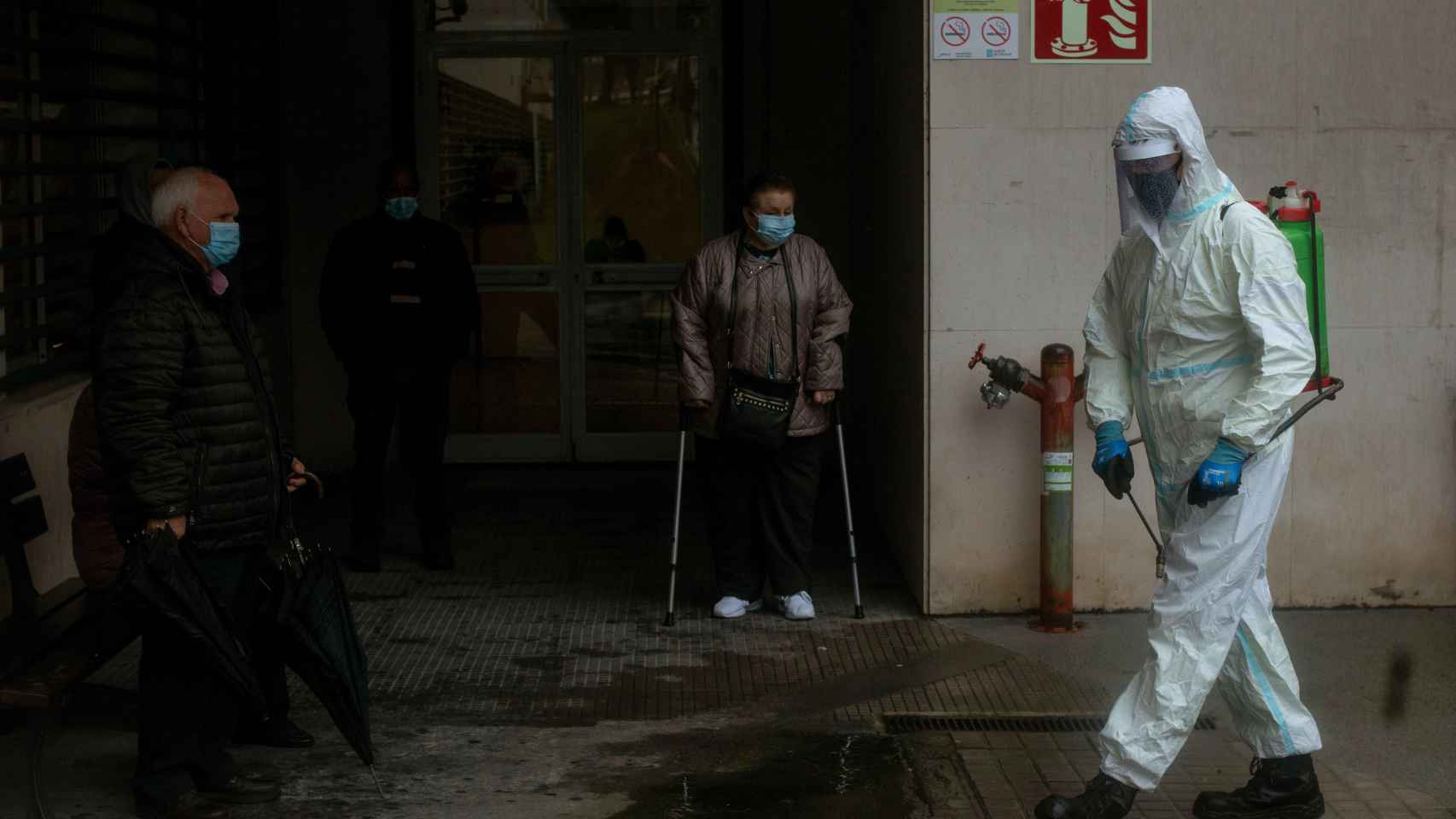 Un empleado municipal desinfecta el acceso al Complejo Hospitalario Universitario de Ourense (CHUO).