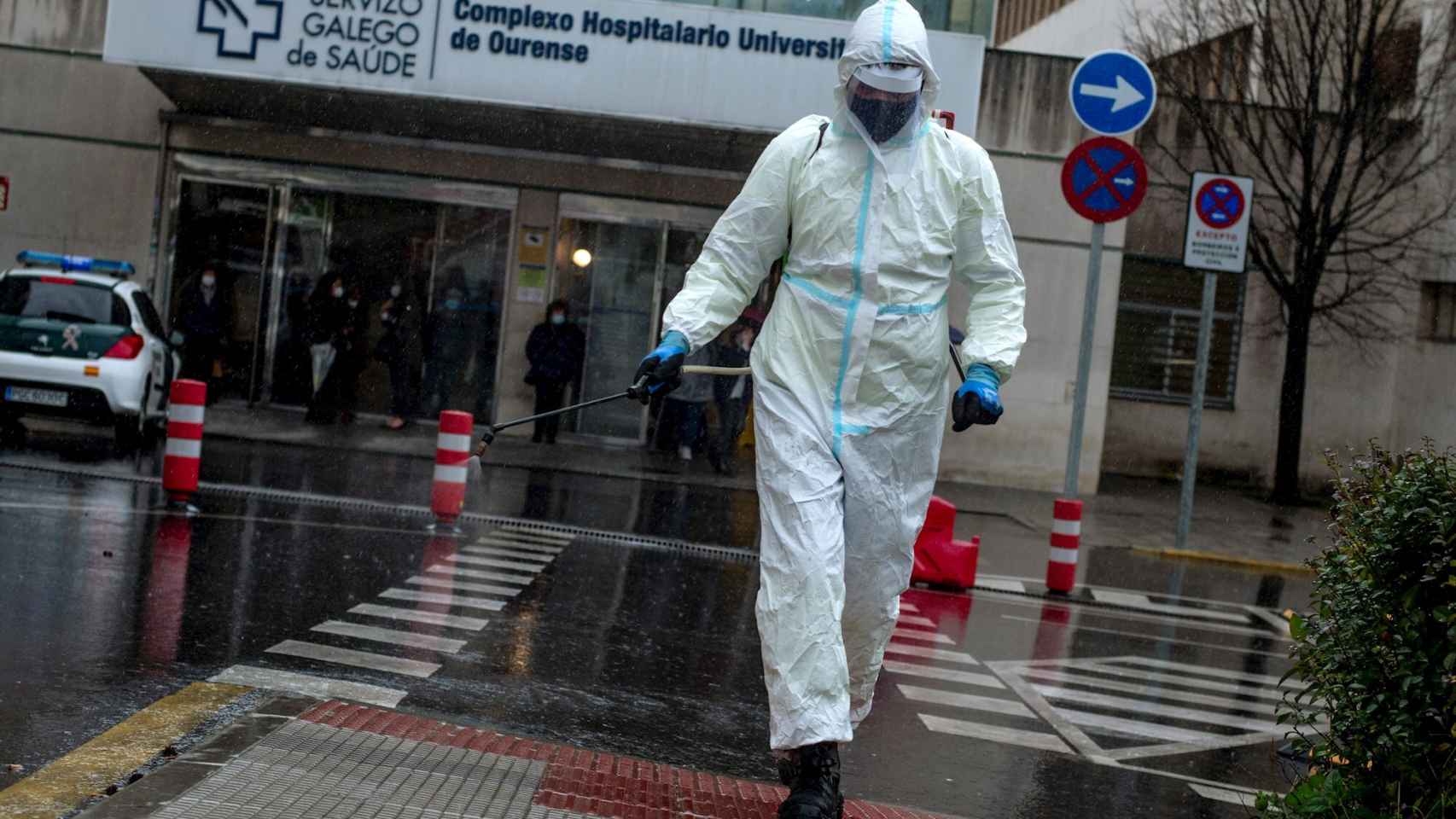 Un empleado municipal desinfecta el acceso al Complejo Hospitalario Universitario de Ourense (CHUO).
