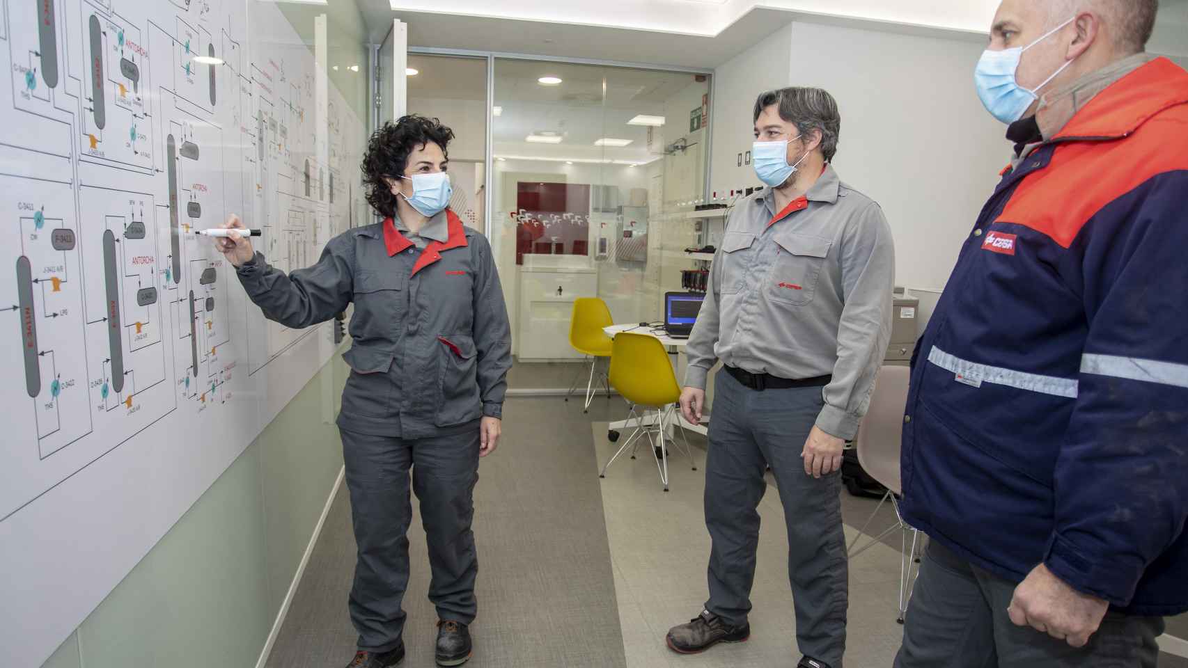 Esther González repasa las tareas con varios trabajadores de la planta química.