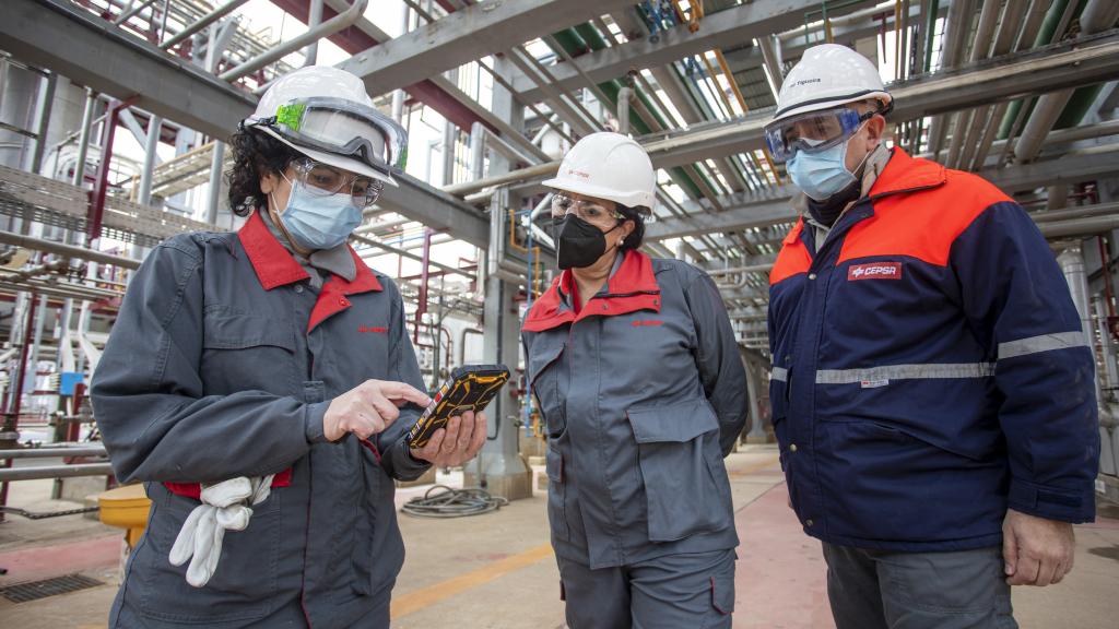 Esther González junto a dos trabajadores, dentro de una de las instalaciones de la planta.