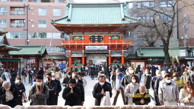 Varias personas rezando en Japón.