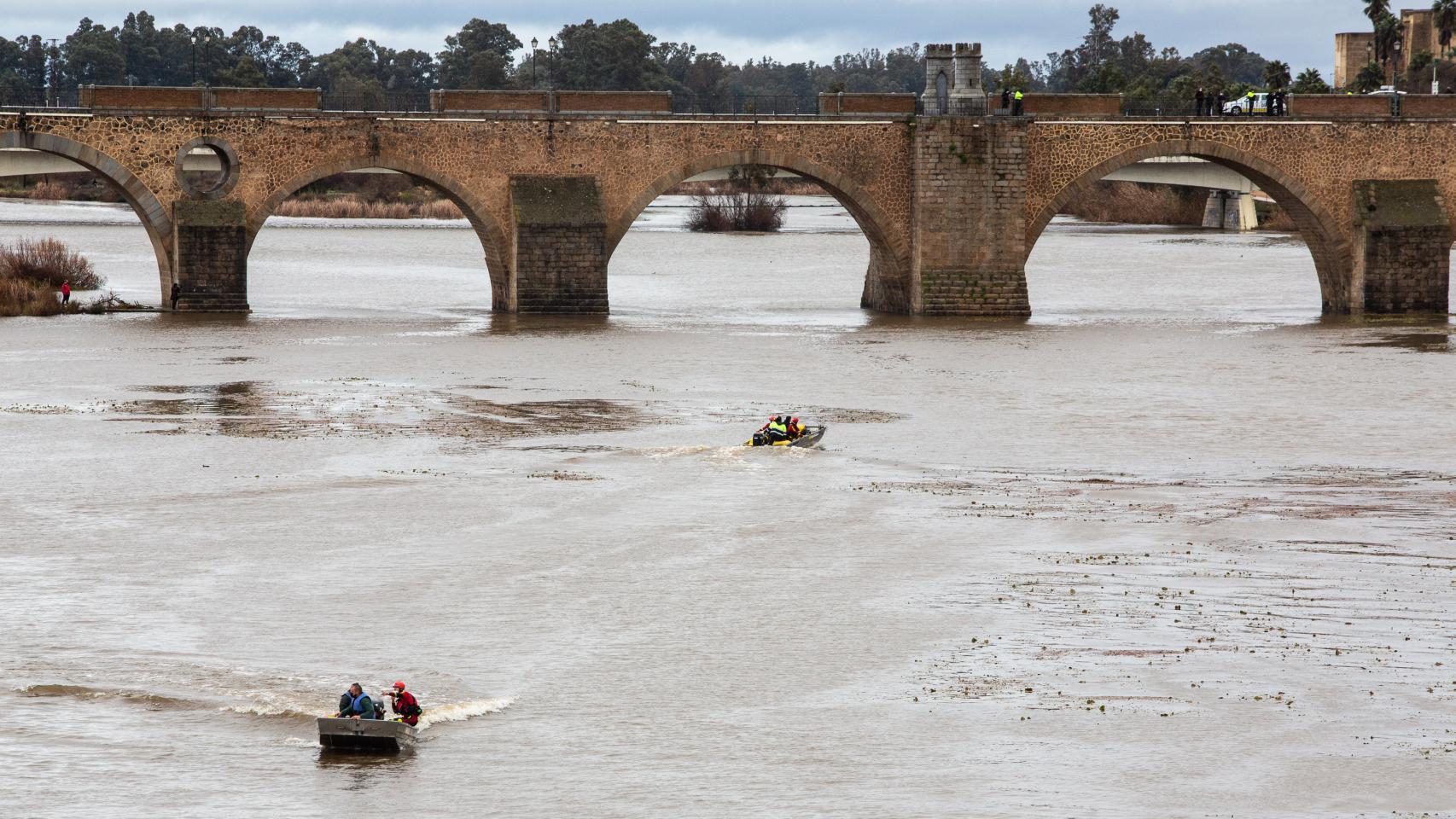 El Puente de las Palmas, en Badajoz, y los agentes durante la búsqueda de los fallecidos.