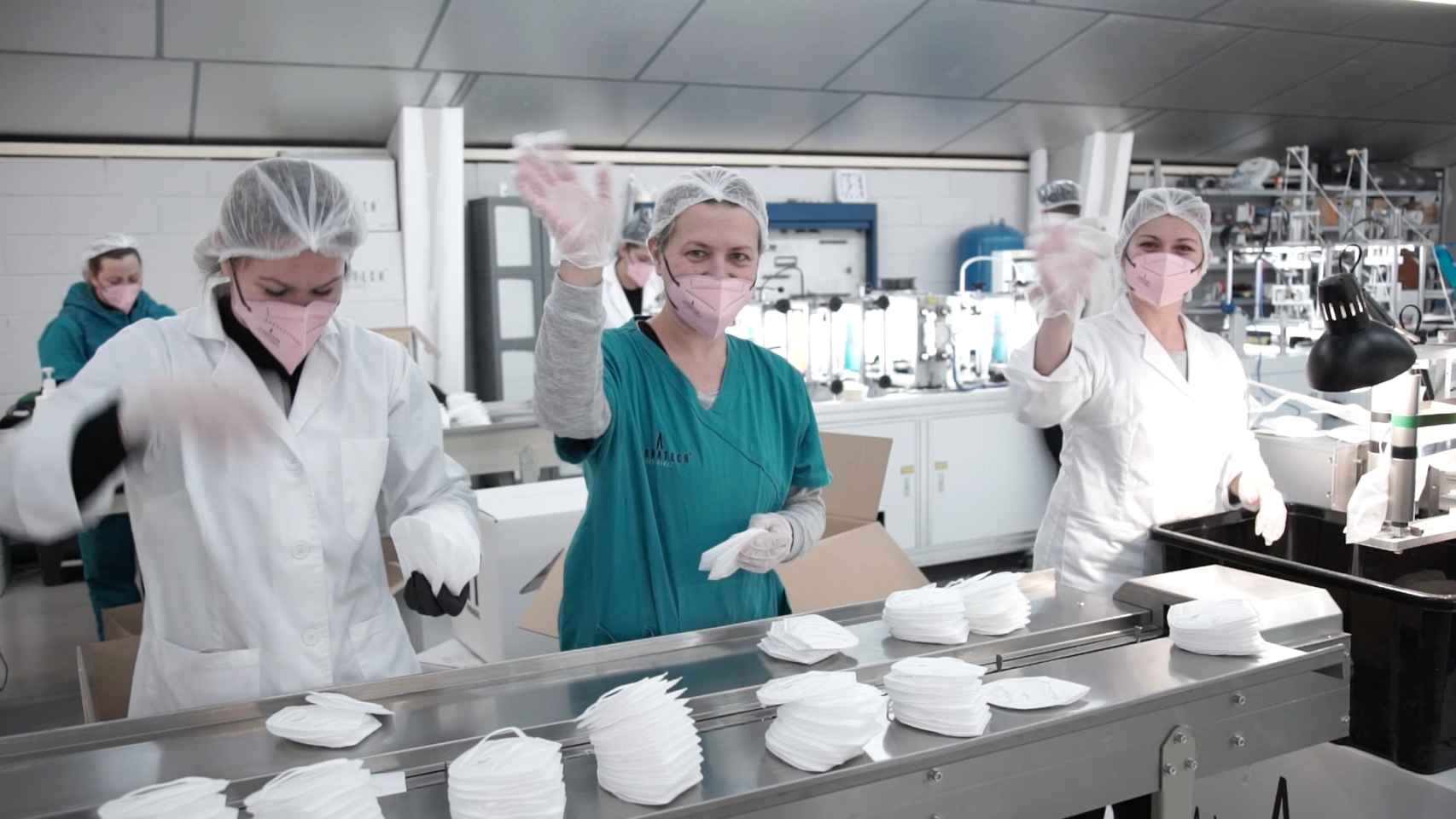 Tres trabajadoras, de 120 empleados que tiene Airnatech Antiviral, saludan mientras recopilan mascarillas FFP2.