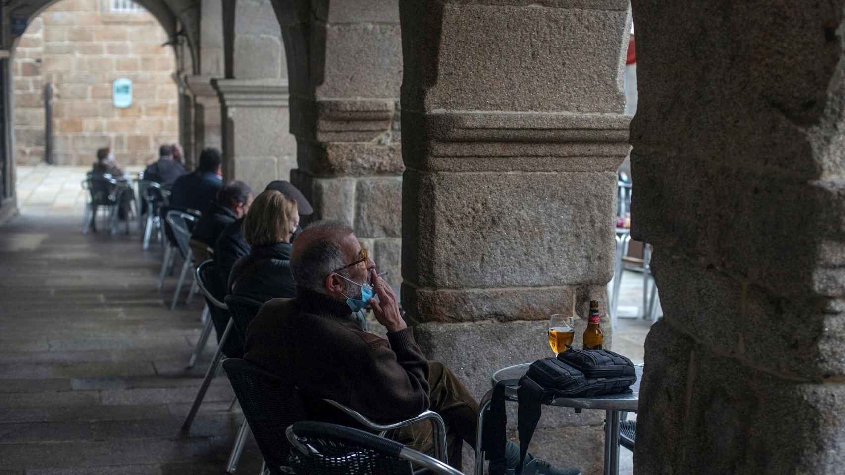 Un hombre toma una cerveza en la terraza de un bar de Orense.