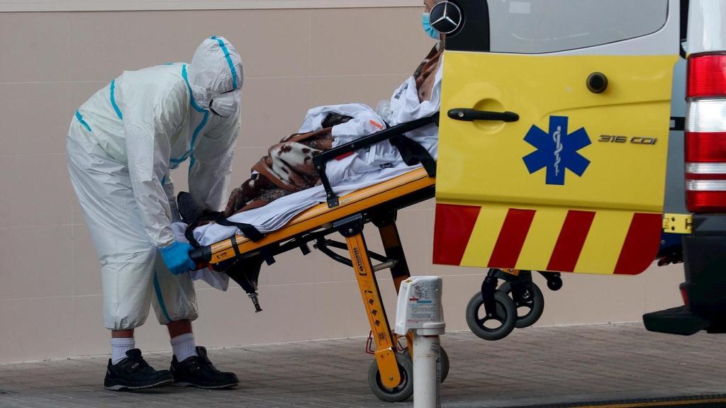 Un sanitario traslada a un enfermo en el Hospital Clínico de Valencia.