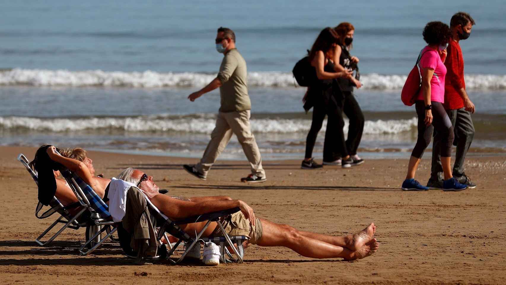 Varias personas toman el sol en la Playa de la Malvarrosa de Valencia el 27 de enero de 2021. EFE/Kai Försterling