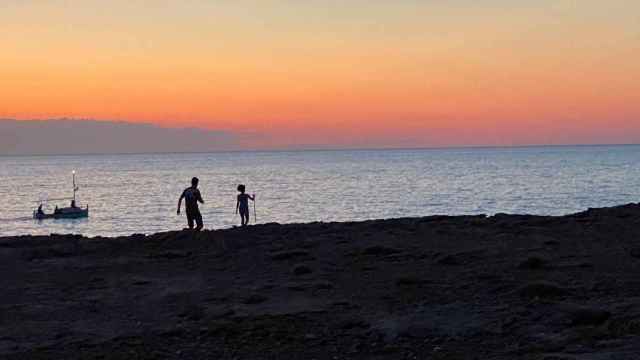 Un padre y su hijo pasean durante un atardecer en Ibiza. FOTO: J. A.
