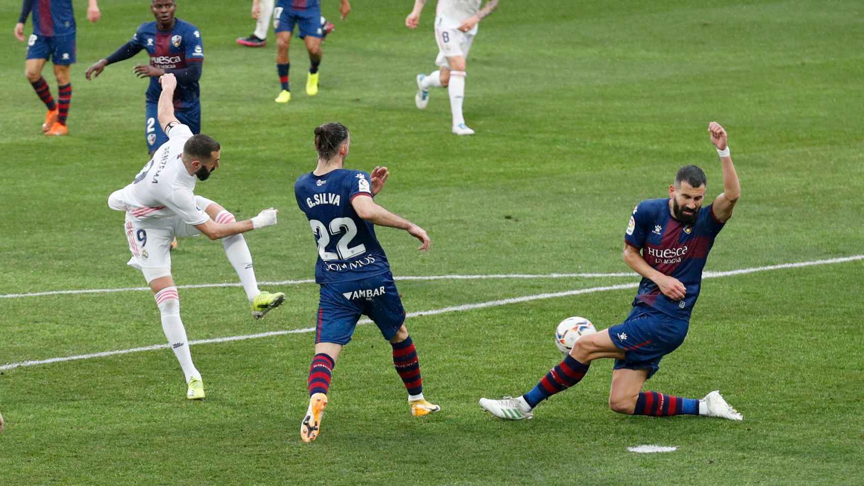 Benzema dispara a la portería del Huesca pero la pelota es despejada por un jugador rival