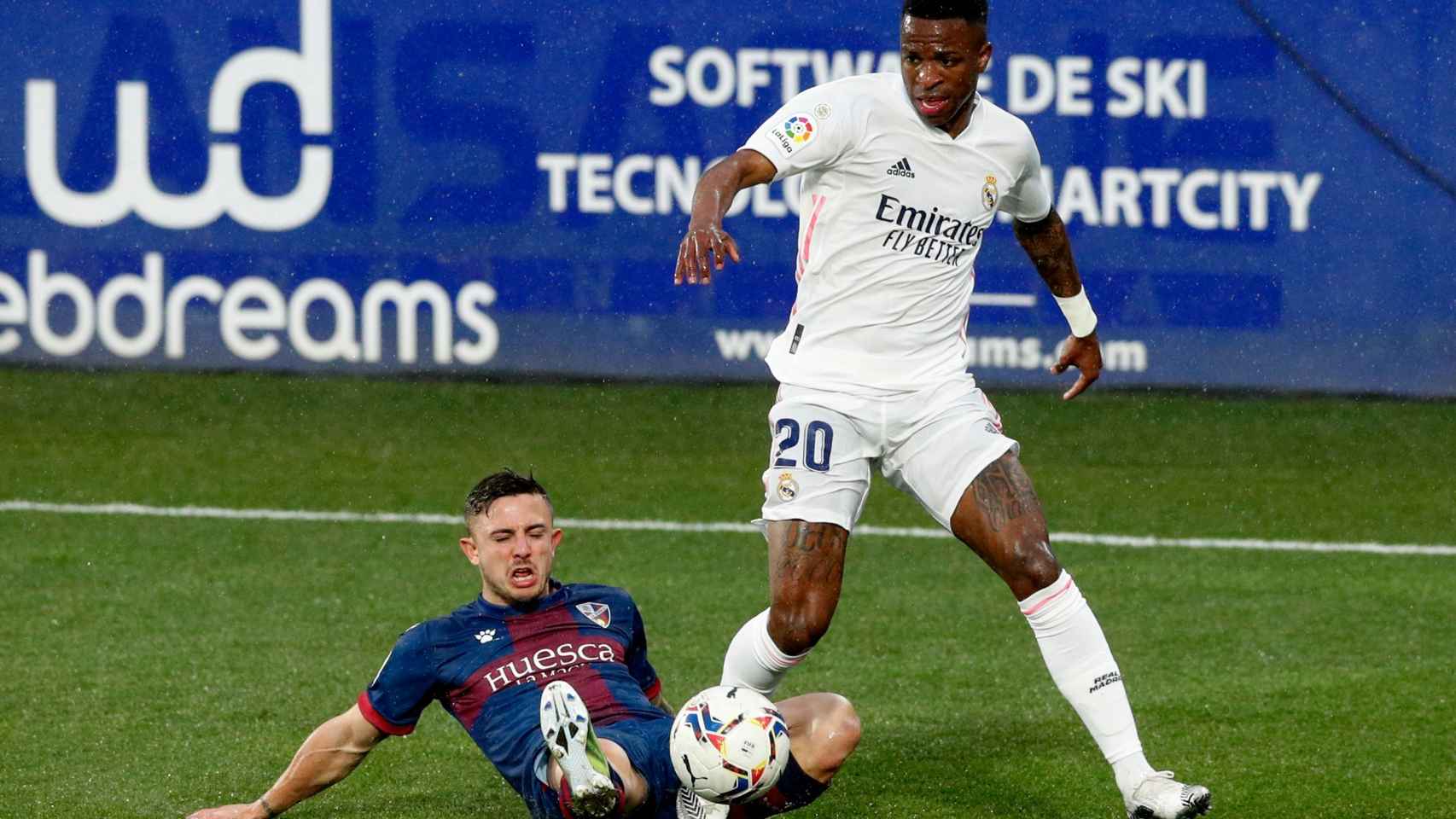 Vinicius evita la presión de un jugador del Huesca y avanza en la jugada
