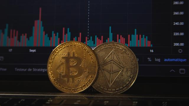 Monedas de bitcoin y ethereum sobre gráficas de cotización.