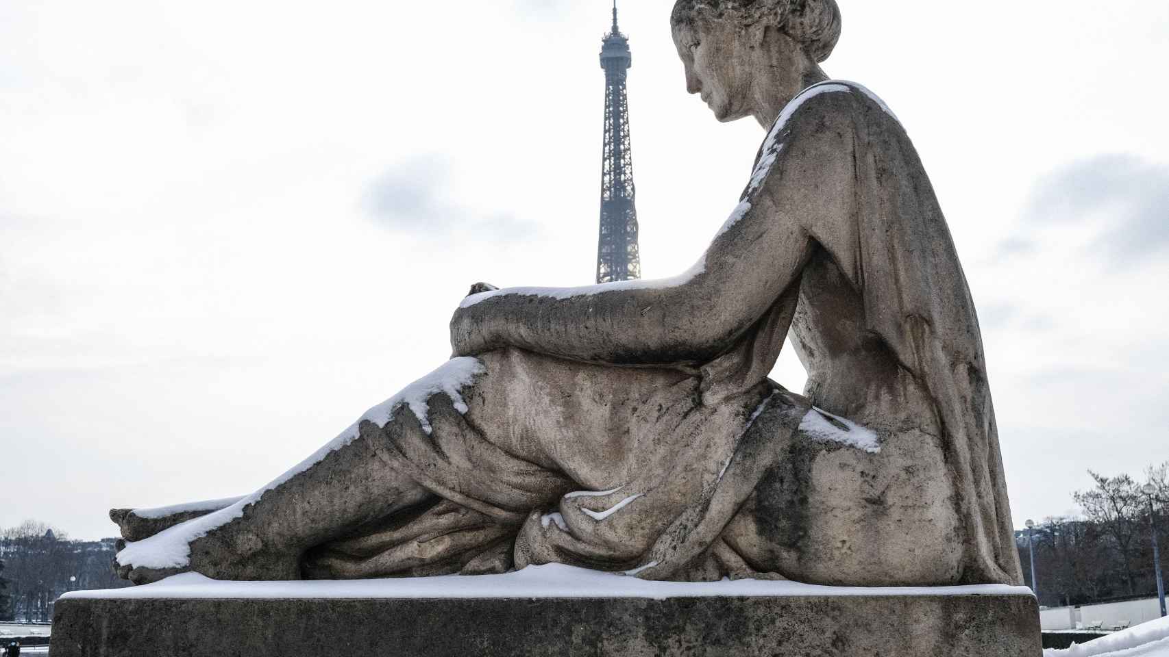 Cae la nieve cae sobre una estatua en la Plaza del Trocadero en París.