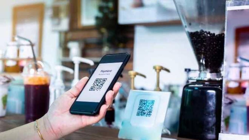 Una persona escanea un código QR en una cafetería.