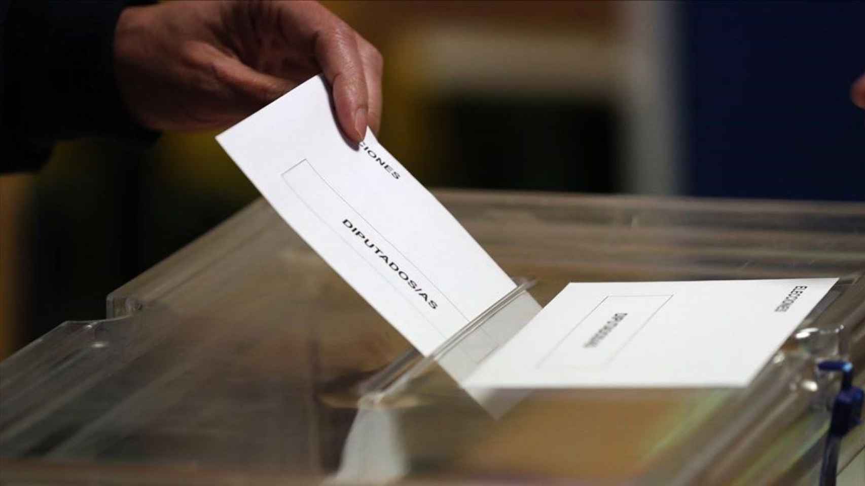 Una papeleta entrando en una urna, durante unas elecciones generales.
