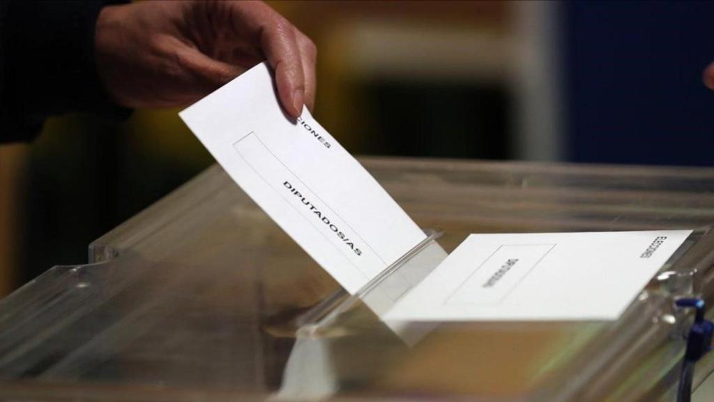 Una papeleta entrando en una urna, durante unas elecciones generales.
