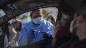 Una mujer mayor de 90 años recibe desde el coche la vacuna de Pfizer contra la Covid-19, en una carpa habilitada en la explanada del centro de salud del municipio Lora del Río.