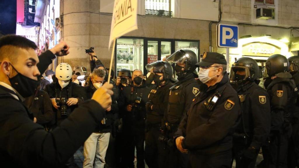 Imagen de un manifestante en frente de la un agente de la Policía Nacional.