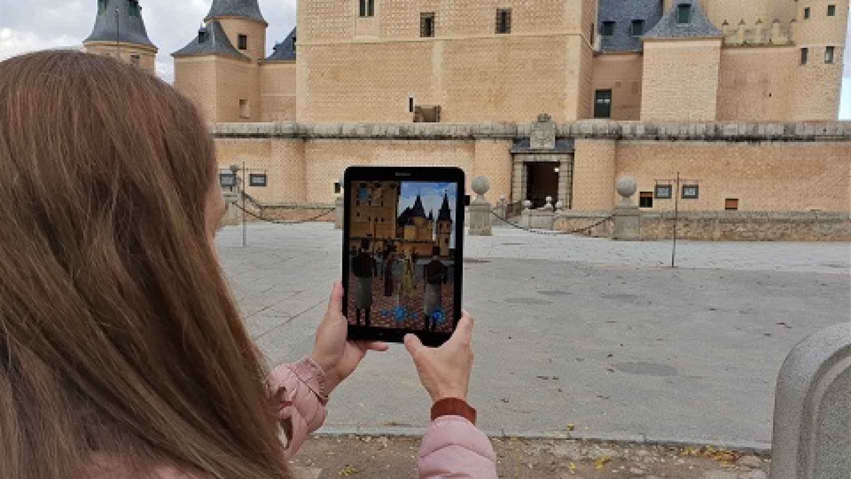 Una turista, con una aplicación de realidad aumentada de Telefónica para Segovia. FOTO: Telefónica.