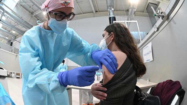 Una sanitaria pone la vacuna contra la Covid-19 a una mujer en el hospital Enfermera Isabel Zendal.
