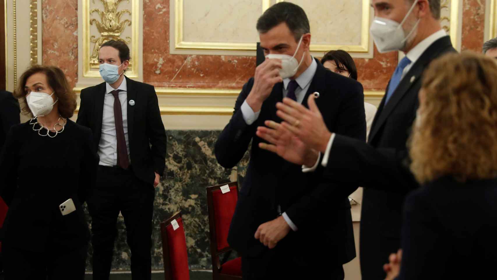 El Rey Felipe VI, entre Pedro Sánchez y Meritxell Batet, junto a Carmen Calvo y, de fondo, Pablo Iglesias con las manos en los bolsillos.