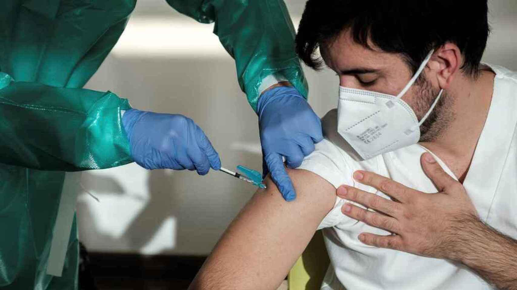 Un sanitario administrando una vacuna.