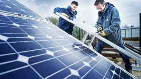 Dos trabajadores instalando placas solares.