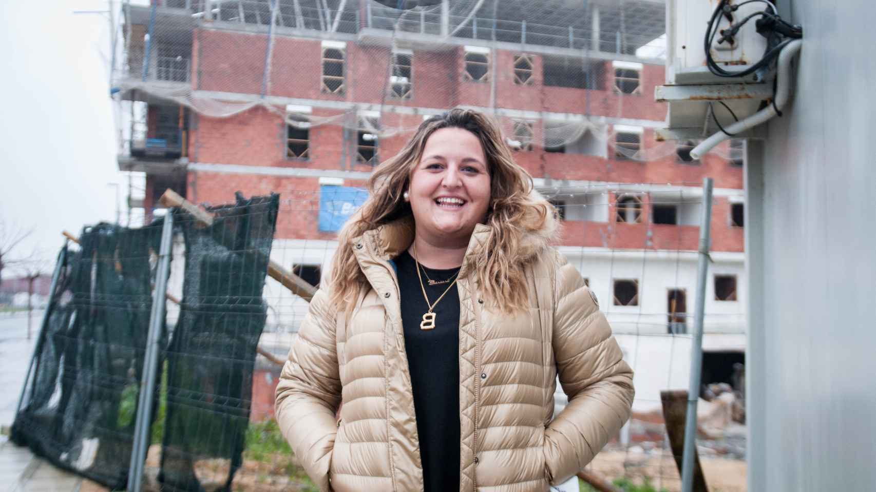 Bárbara Argüelles, dueña de la promotora PJR. De fondo, el edificio que está construyendo en Lugones (Asturias).