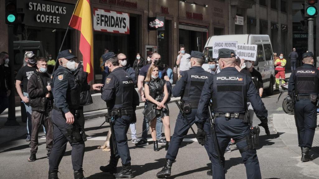 Varios agentes ante un grupo de extrema derecha en una manifestación por la Sanidad Pública.