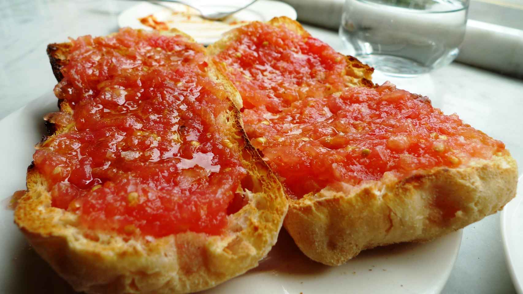 Una imagen de pan con tomate.