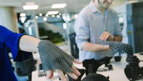 Dos emprendedores realizan pruebas de guantes hechos con impresión 3D en las instalaciones de 3DFactory Incubator.