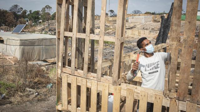 Un joven marroquí apuntala los palés sobre los que volverá a levantar su casa en el campamento de inmigrantes de Palos de la Frontera (Huelva).