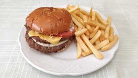 La nueva hamburguesa de Burger King, la 'Queen Cheese', emplatada junto a unas patatas fritas.