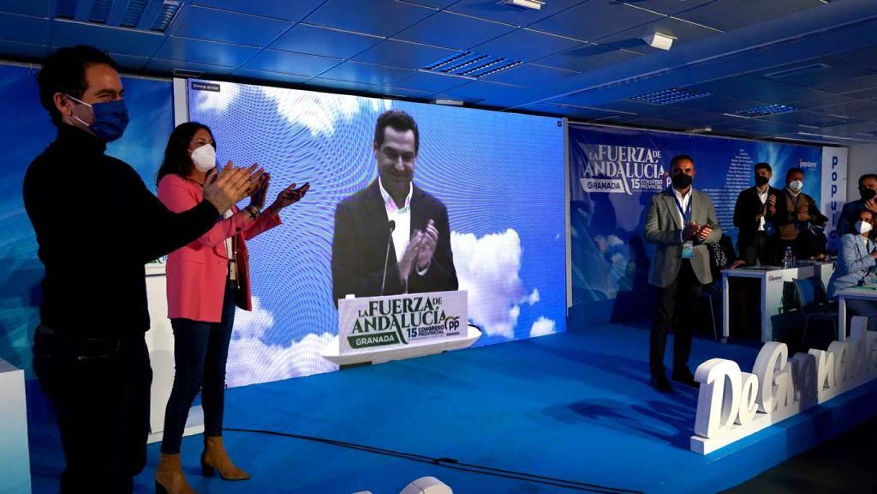 El presidente de la Junta, Juanma Moreno, en la pantalla en el congreso del PP de Granada.