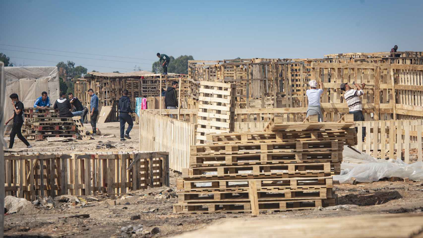Las personas que pueblan el asentamiento de Palos, que sufrió un fuego a mediados de febrero, se afanan en reconstruir sus casas.