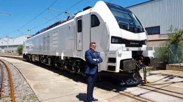 Íñigo Parra, presidente de Stadler Valencia, junto a una locomotora producida en la factoría. EE