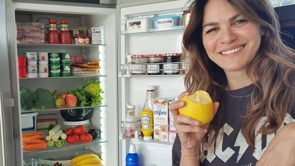 Fabiola Martínez, junto a su nevera, cargada de frutas y verduras.