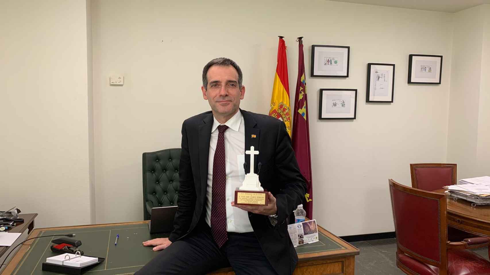 Juan José Liarte sujetando una réplica de la cruz de Callosa de Segura en su despacho en la Asamblea Regional.
