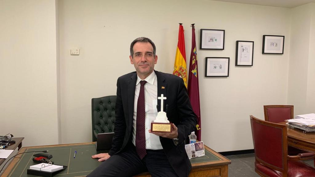 Juan José Liarte sujetando una réplica de la cruz de Callosa de Segura en su despacho en la Asamblea Regional.