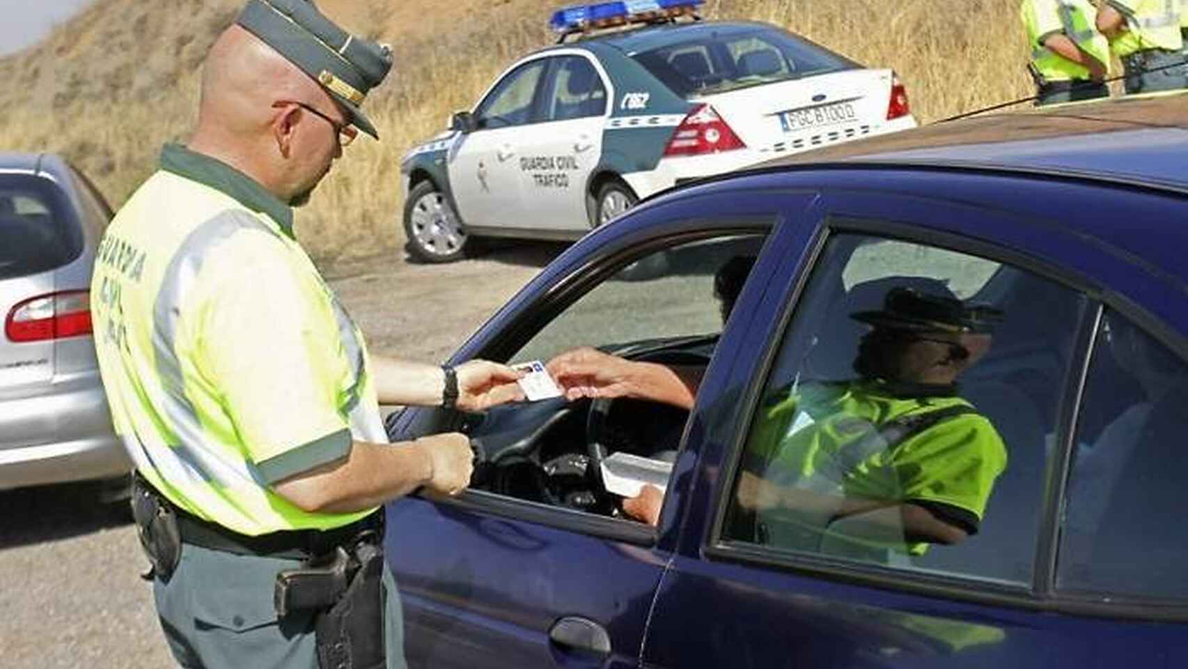 Un agente de la Guardia Civil le pide la documentación a un conductor.