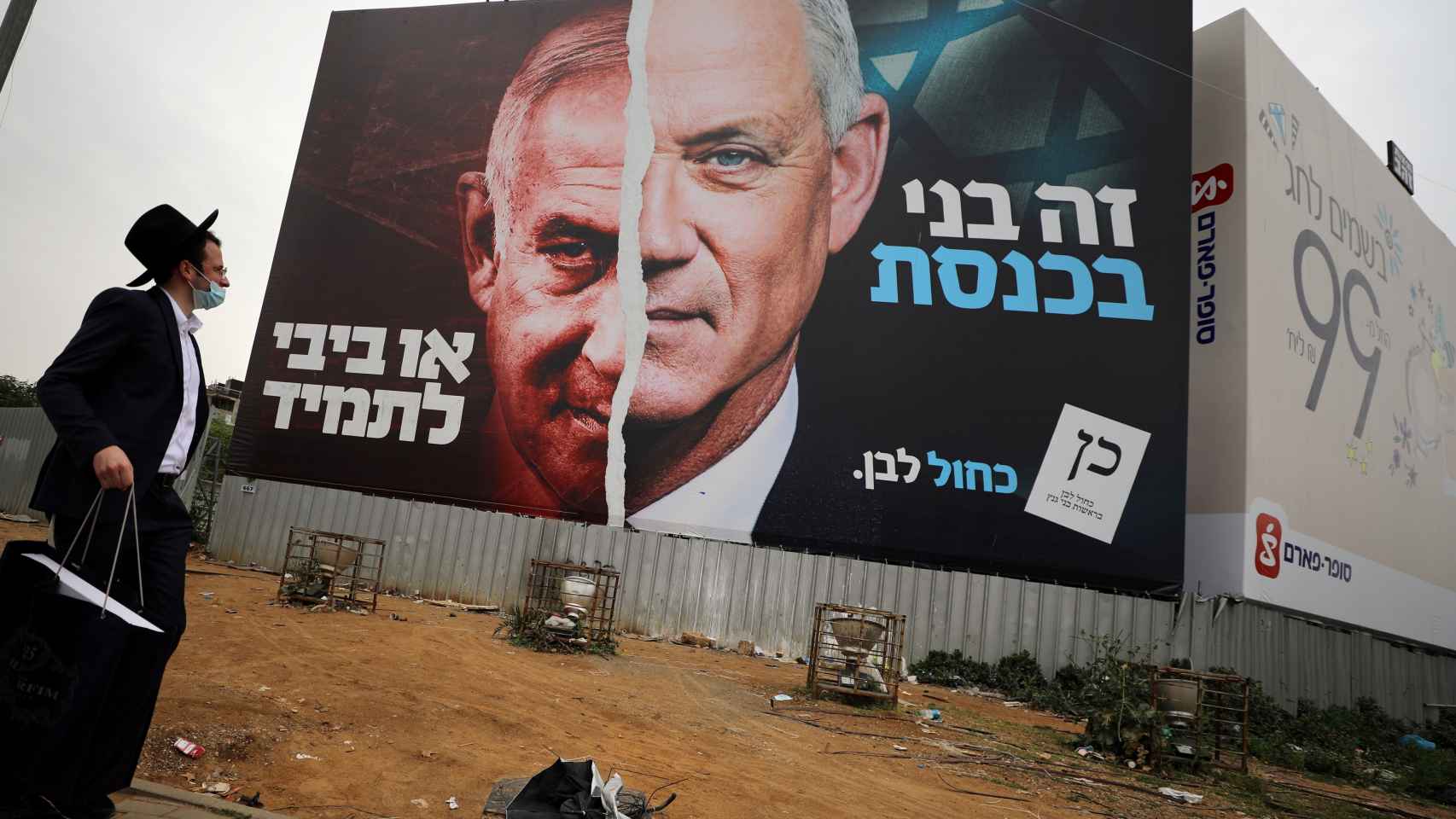 Un judío ultraortodoxo ante un cartel electoral del partido centrista Azul y Blanco, donde aparece Netanyahu (i) enfrentado a Beny Gantz (d).