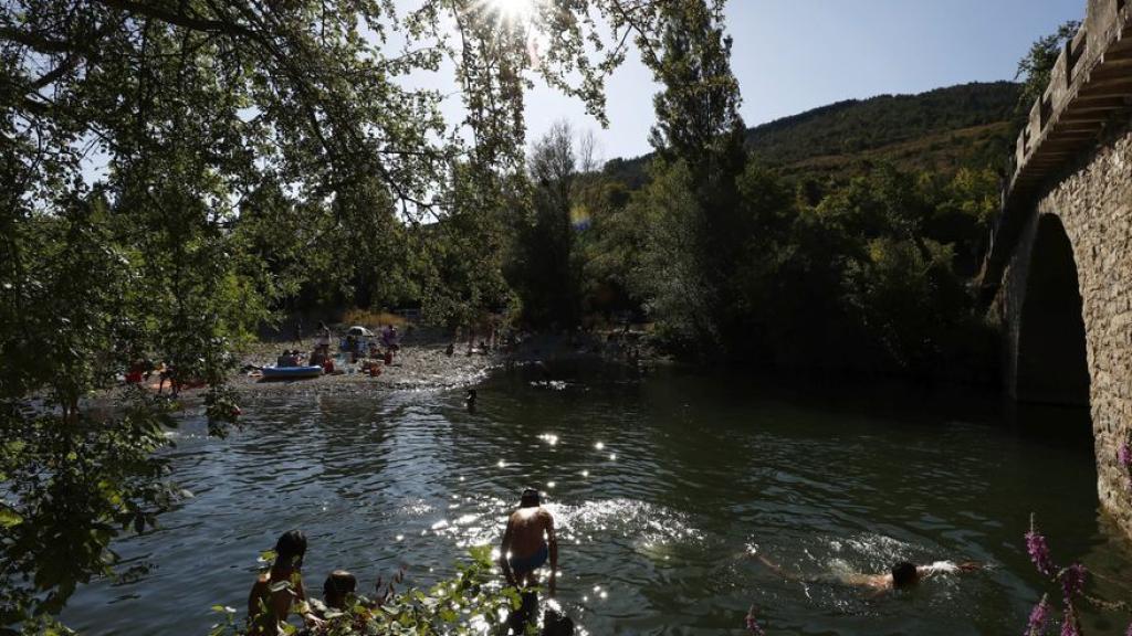 Un grupo de personas disfruta de un baño en el río Arga en la localidad navarra de Irozt.