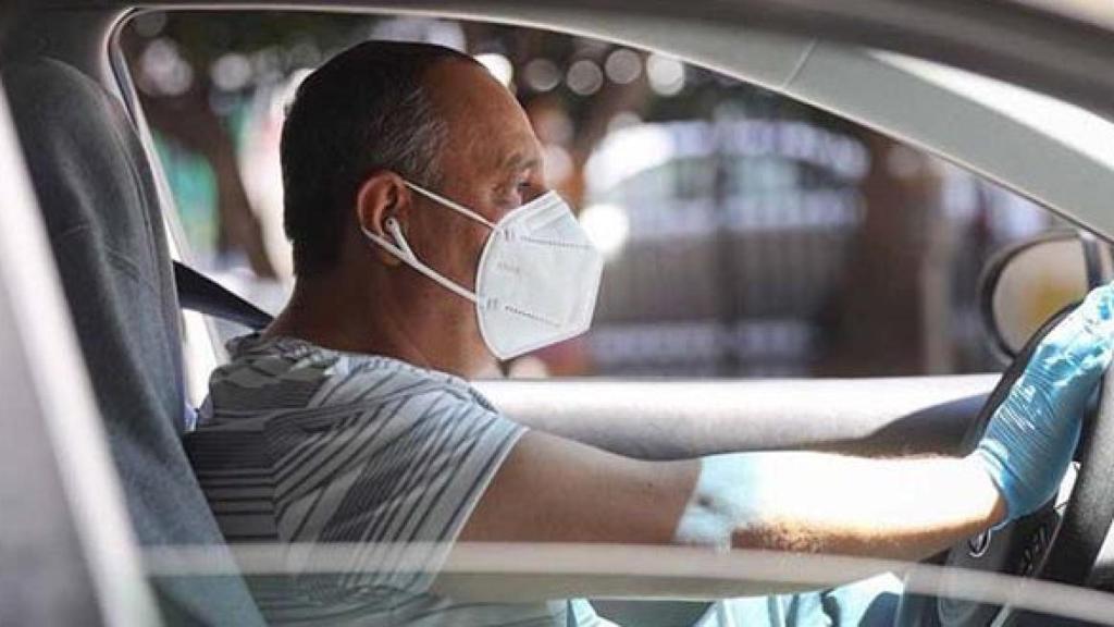 Un conductor circulando con su mascarilla puesta.