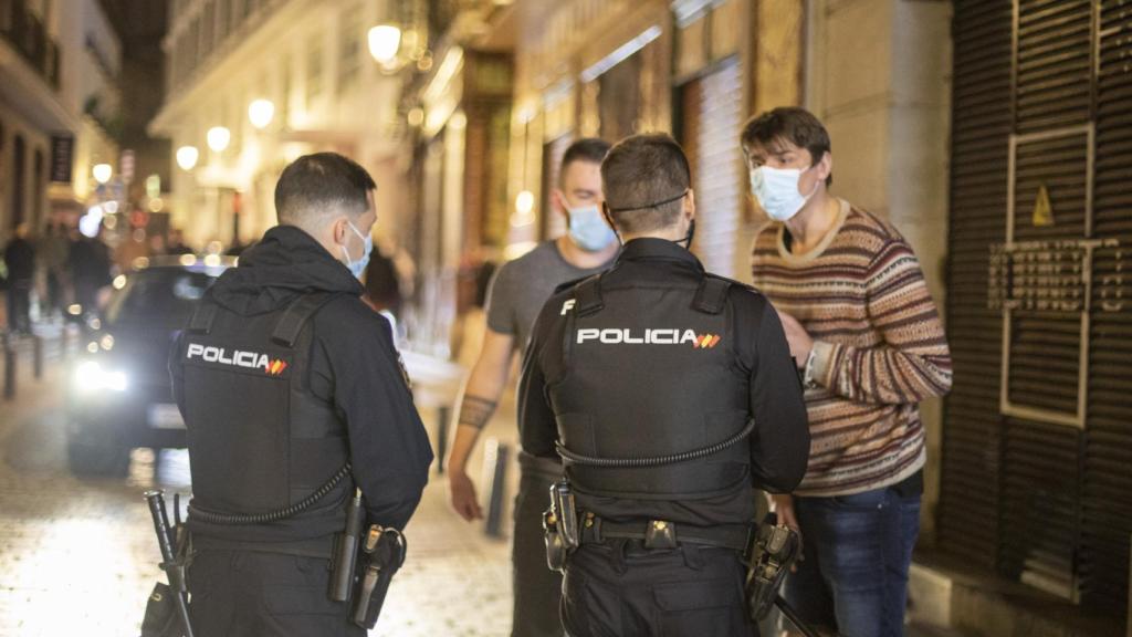 Dos policías increpan a dos turistas.