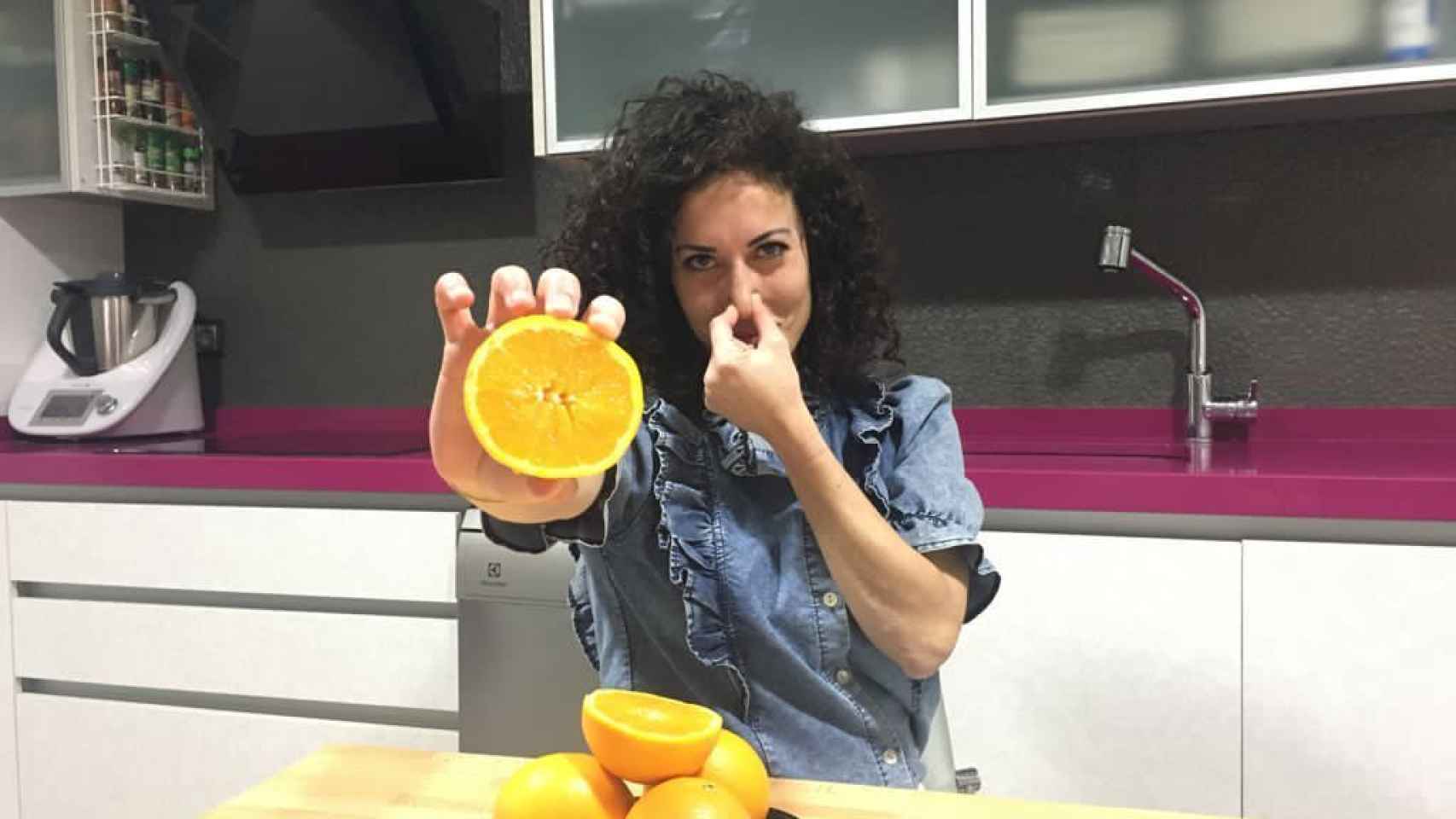 Una mujer con unas naranjas en la mano.