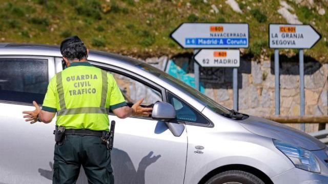 Un Guardia Civil para un vehículo para multar al conductor.