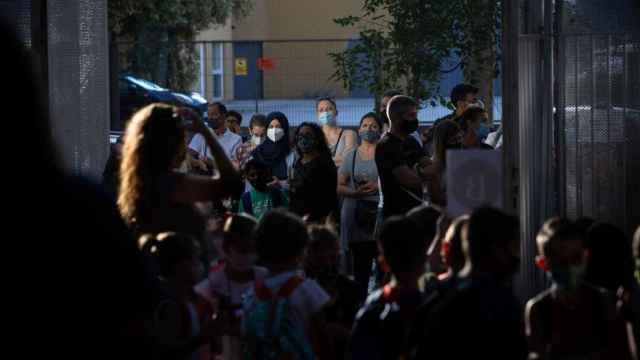 Padres y alumnos esperan a las puertas de un colegio en Cataluña.